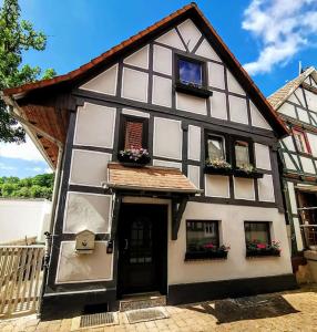 ein schwarzweißes Haus mit zwei Fenstern und einer Tür in der Unterkunft Fachwerkhaus mitten in der Altstadt - Ferien in Rotenburg in Rotenburg an der Fulda