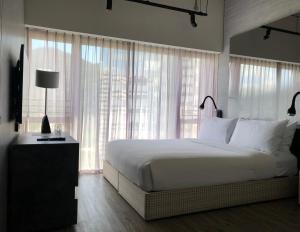 a bedroom with a white bed and a large window at Southside by Ovolo in Hong Kong
