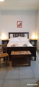 a bedroom with a bed and a table and a chair at Chambre d'Hotes Lamanon, avec ou sans petit déjeuner - Domaine Les Peupliers - in Lagnes