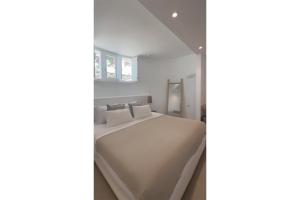 a bedroom with a bed with white sheets and pillows at KAMEO, Antiparos in Antiparos