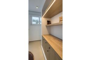 a kitchen with wooden cabinets and a shelf at KAMEO, Antiparos in Antiparos