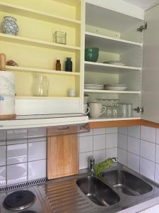 a kitchen with a sink and open shelves at Åvillan - River house in Lagan +13 photos