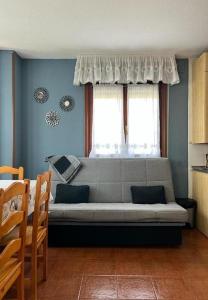 een woonkamer met een bank voor een raam bij Apartamento con jardín privado Mogro Las Dunas in Mogro