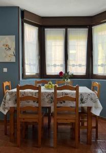 een eetkamer met een tafel, stoelen en ramen bij Apartamento con jardín privado Mogro Las Dunas in Mogro