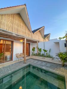 a villa with a swimming pool and a house at Astakaia Cottage in Ciwidey