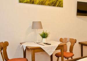 una mesa con dos sillas y una mesa con una planta. en Landhotel Dorfschmiede Konditorei-Café-Restaurant, en Höchenschwand