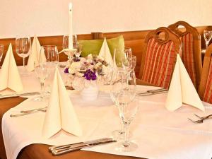 einen Tisch mit Weingläsern und Blumen darauf in der Unterkunft Landhotel Dorfschmiede Konditorei-Café-Restaurant in Höchenschwand