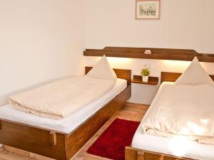2 camas individuales en una habitación con alfombra roja en Landhotel Dorfschmiede Konditorei-Café-Restaurant, en Höchenschwand