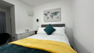 a bedroom with a bed with a yellow blanket on it at The En-Suite Escape. 4-Bed Luxury Stay in Castleford