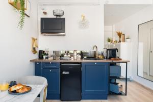 una cocina con armarios azules y fregadero en SARAH - Design Studio Lumineux Bergson, en Saint-Étienne