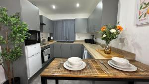 a kitchen with a table with plates and bowls on it at The En-Suite Escape. 4-Bed Luxury Stay in Castleford