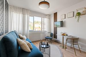 a living room with a blue couch and a table at SARAH - Design Studio Lumineux Bergson in Saint-Étienne