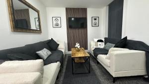 a living room with two couches and a table at The En-Suite Escape. 4-Bed Luxury Stay in Castleford