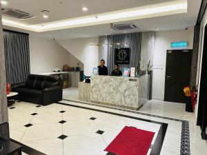 a lobby with a reception desk and a man standing at a counter at T SQUARE HOTEL (IPOH) in Ipoh