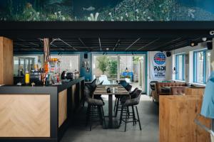 a restaurant with a bar with stools around a table at Duikresort Sub Ocean Hotel in Oud-Vossemeer
