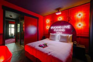 a red bedroom with a bed with a sign on it at SUPPER Hotel in Amsterdam