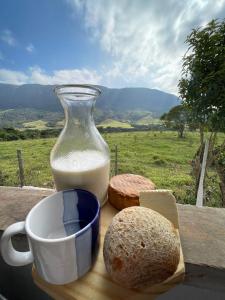 uma mesa com um jarro de leite e um pão em Pousada Vale da Canastra em São José do Barreiro
