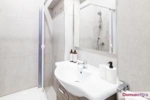 a white bathroom with a sink and a shower at La Casetta agli Orefici By DomusExtra in Naples