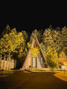 a small house with a triangle roof in front of trees at Pavliani4rest - Luxury Cabins in Pavliani