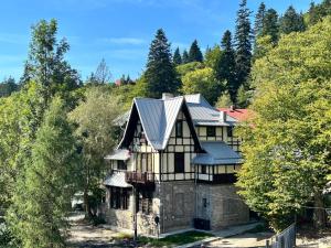 une maison avec un toit métallique sur une colline dans l'établissement Mansarda veche - central, balcony, self check-in, à Sinaia