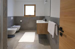ein Bad mit einem Waschbecken, einem WC und einem Fenster in der Unterkunft Innerpasthof 