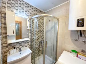 ein Bad mit einer Dusche und einem Waschbecken in der Unterkunft Nikki’s Apartment Podgorica in Podgorica