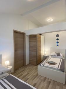 a white bedroom with a large bed and wooden floors at Albert apartments Zagreb airport in Velika Gorica