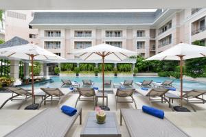 una imagen de una piscina de hotel con sillas y sombrillas en The Beverly Hotel Pattaya, en Pattaya South