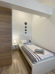 a white room with a bed in a room at Albert apartments Zagreb airport in Velika Gorica