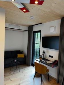 ein Wohnzimmer mit einem Sofa und einem TV an der Wand in der Unterkunft Ferienbahnhof Reichenbach in Dahn