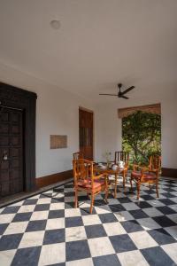 a dining room with a table and chairs on a checkered floor at LohonoStays Library Sadhrana Bagh in Gurgaon