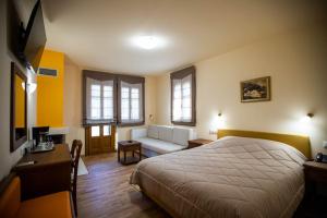 1 dormitorio con 1 cama y sala de estar con sofá en Rentinia Inn en Rentína