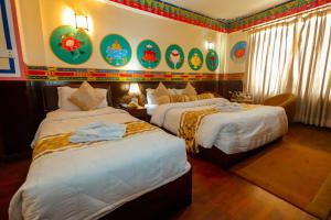 Habitación de hotel con 2 camas y pinturas en la pared en Kathmandu Eco Hotel, en Katmandú