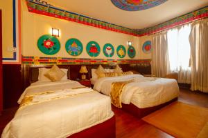 a bedroom with two beds and a wall with decorations at Kathmandu Eco Hotel in Kathmandu