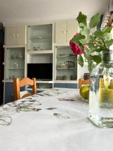 een tafel met een vaas met een bloem erop bij Apartamento con jardín privado Mogro Las Dunas in Mogro