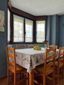 een eettafel met stoelen en een wit tafelkleed bij Apartamento con jardín privado Mogro Las Dunas in Mogro