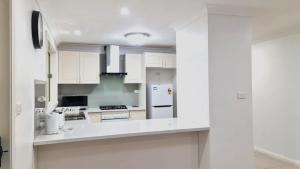 a kitchen with white cabinets and a white counter top at 3 Bed Room, Luxury Home in Schofields