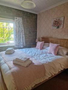 1 dormitorio con 1 cama grande y 2 toallas. en Highcroft & Windale @ Wetheral Cottages, en Great Salkeld