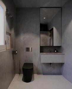 a bathroom with a black toilet and a sink at Architect’s home pad - Valletta in Valletta