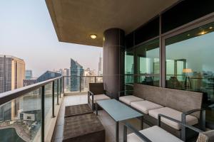 balcón con bancos y vistas a la ciudad en Maison Privee - Dreamy Apt with Jaw-Dropping Marina Views, en Dubái