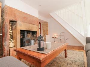 a living room with a fireplace and a wooden table at Abbey Cottage Montacute in Montacute
