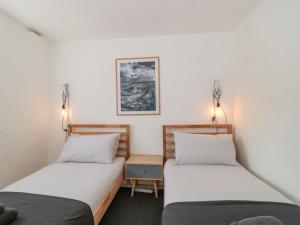 Duas camas num quarto com paredes brancas em Abbey Cottage Montacute em Montacute