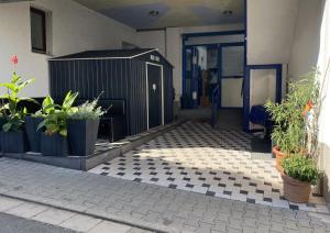 a building with potted plants on a checkered floor at Landgasthaus zum Hirsch in Ramsen