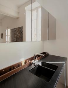 een keuken met een wastafel en een spiegel bij Architect’s home pad - Valletta in Valletta