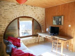 een kamer met een tafel en een bureau met een televisie bij Le Verger Sous Les Vignes in Villeferry