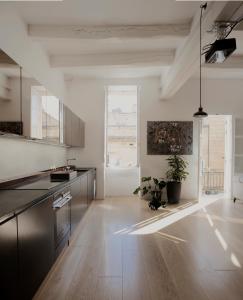 een grote keuken met houten vloeren en een groot raam bij Architect’s home pad - Valletta in Valletta