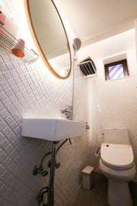 La salle de bains est pourvue d'un lavabo, d'un miroir et de toilettes. dans l'établissement NagNe House Boutique Hanok, à Séoul