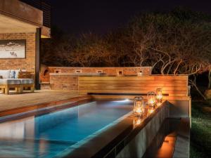una piscina en un patio trasero por la noche en NAKO Safari Lodge, en Dinokeng Game Reserve