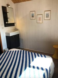 a bedroom with a blue and white striped bed and a sink at Charming House In Pornichet Near The Beach in Pornichet