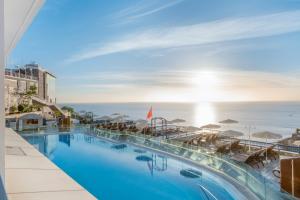 a swimming pool with a view of the ocean at Club Cala Blanca in Taurito